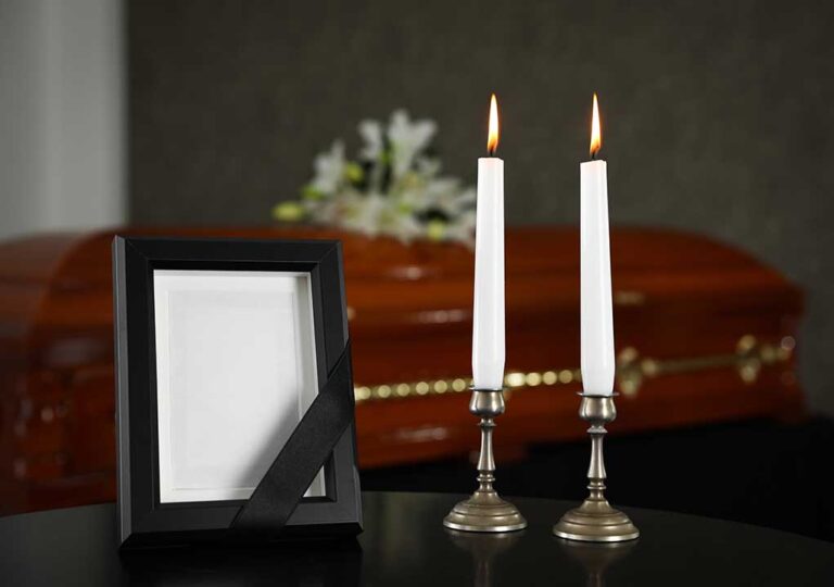 Casket photo frame and two lit candles